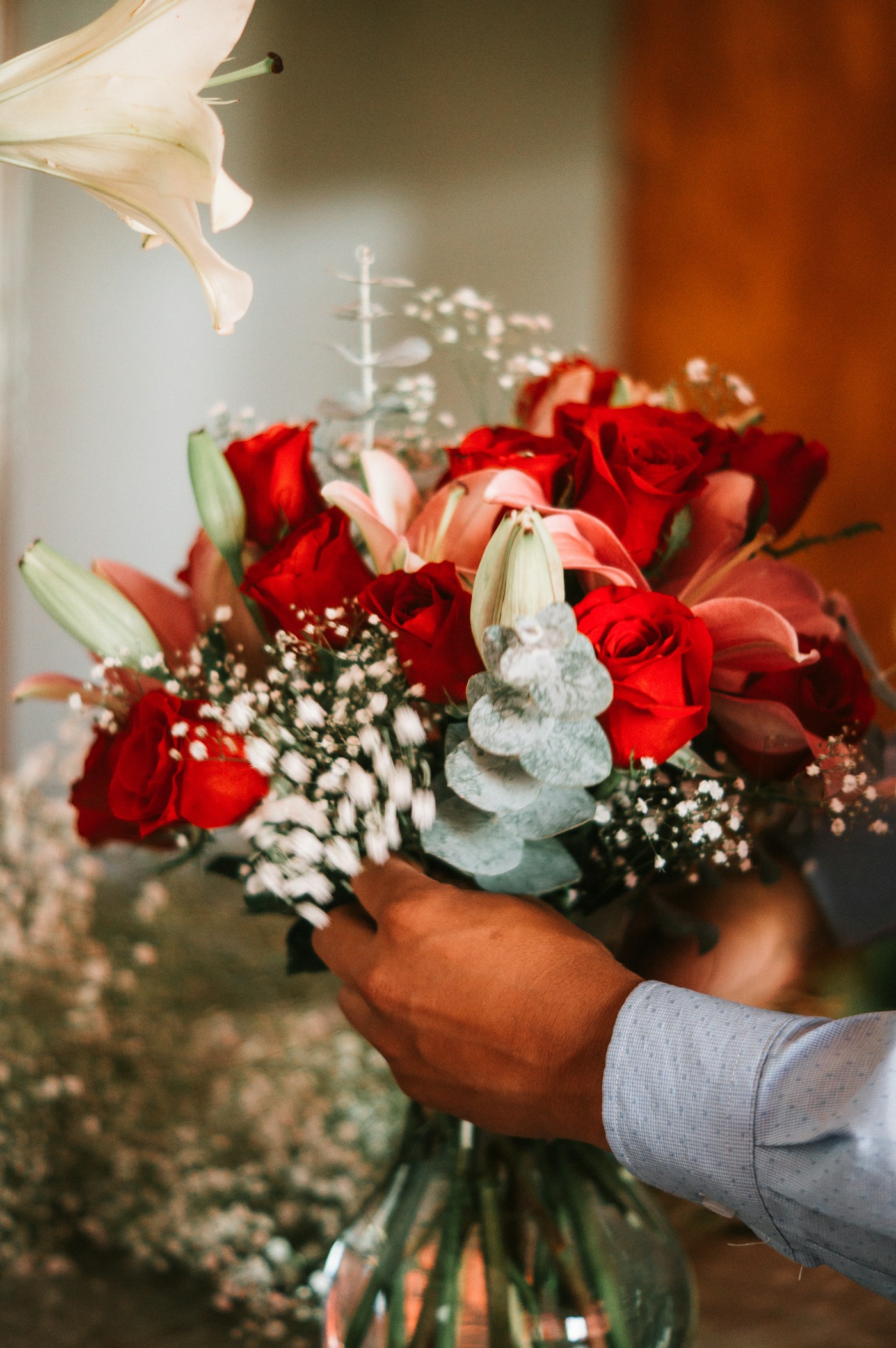 Florista preparando un arreglo de rosas y lirios